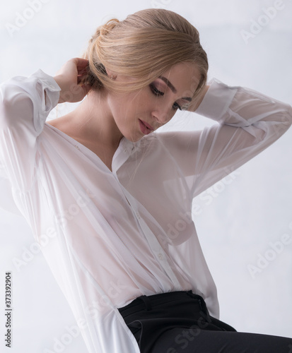 Sexy woman in white office shirt posing on chair