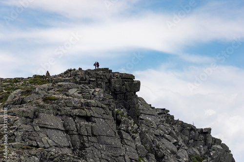 Two hikers pause among the cairns at the top of Bondcliff to take in the view