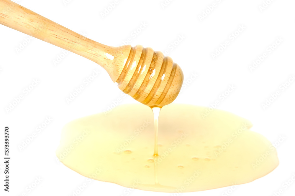 Wooden honey dipper with honey isolated on white background. Wooden honey dipper with honey isolated on white background.