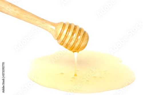 Wooden honey dipper with honey isolated on white background.