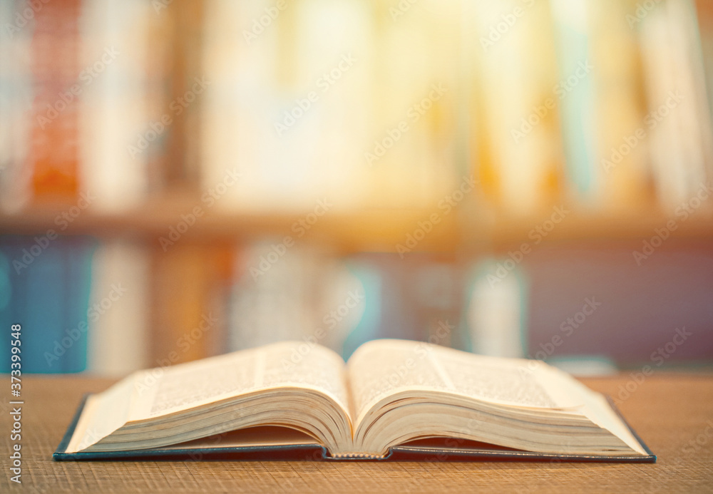 Concept of learning education. Open book on the wooden table in the library Concept of learning education. Open book on the wooden table in the library