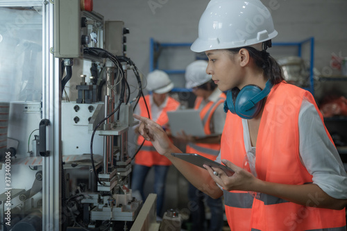 woman working engineering or technical inspection the system  of machinery to ensure working in order by checklist part and quality control, wrkplace with teamwork together. photo