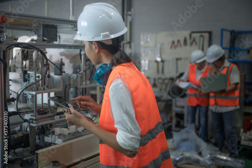 woman working engineering or technical inspection the system  of machinery to ensure working in order by checklist part and quality control, wrkplace with teamwork together photo