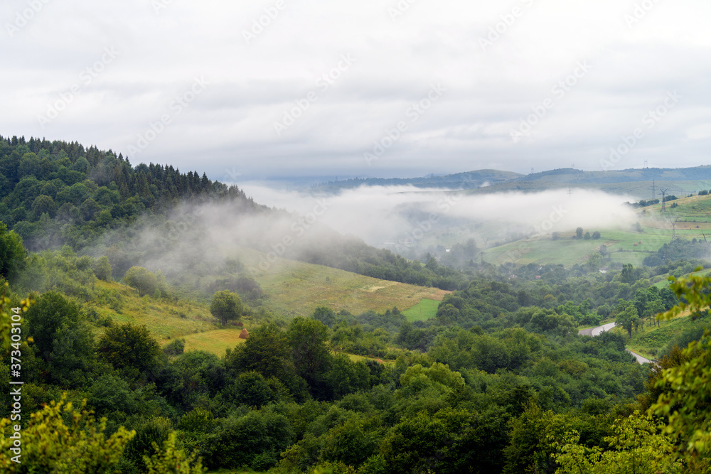 Majestic view on beautiful fog and cloud mountains in mist landscape.