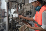 woman working engineering or technical inspection the system  of machinery to ensure working in order by checklist part and quality control