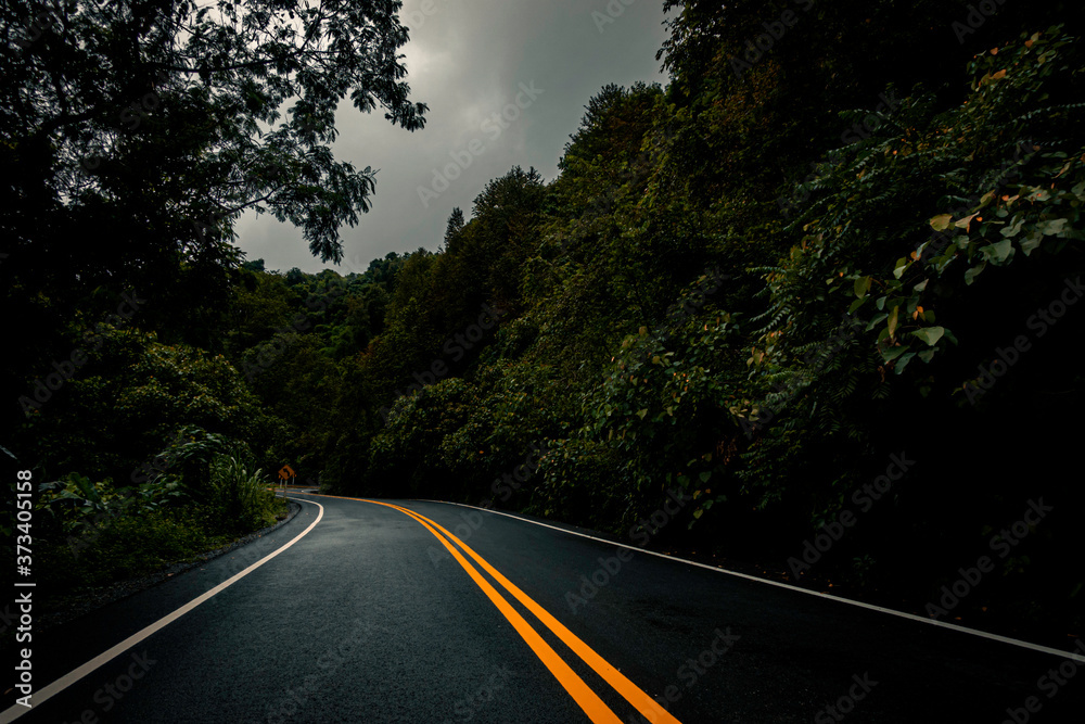Naklejka premium Logistic concept aerial view of countryside road - motorway passing through the serene lush greenery and foliage tropical rain forest mountain landscape