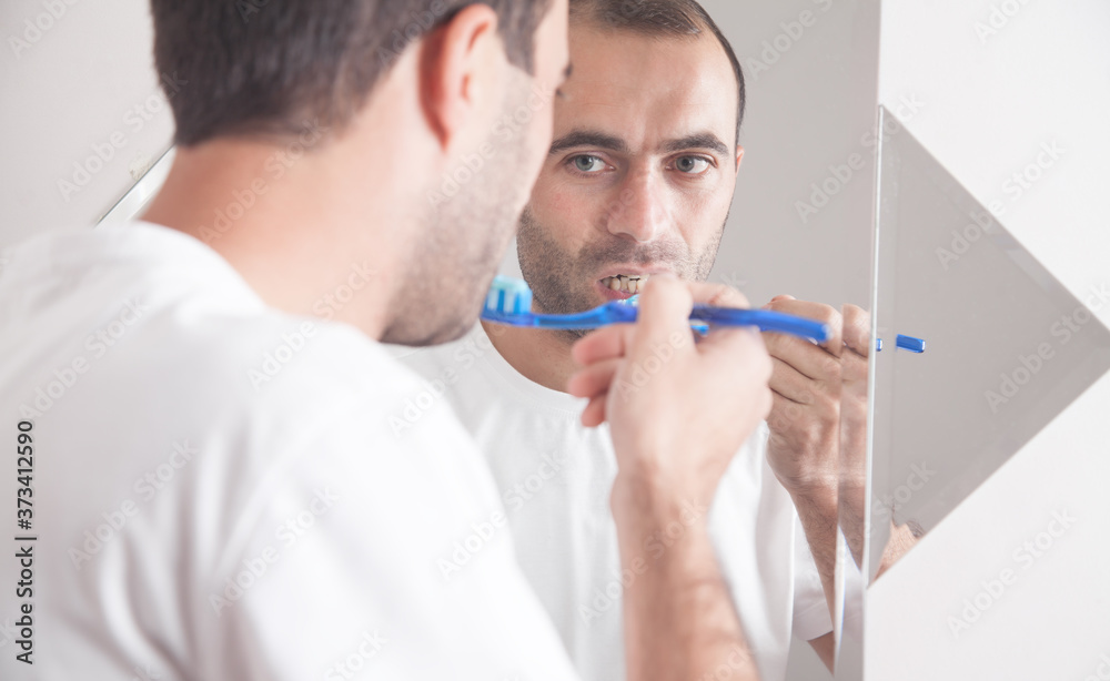 Caucasian man holding toothbrush in the bathroom. Caucasian man holding toothbrush in the bathroom.