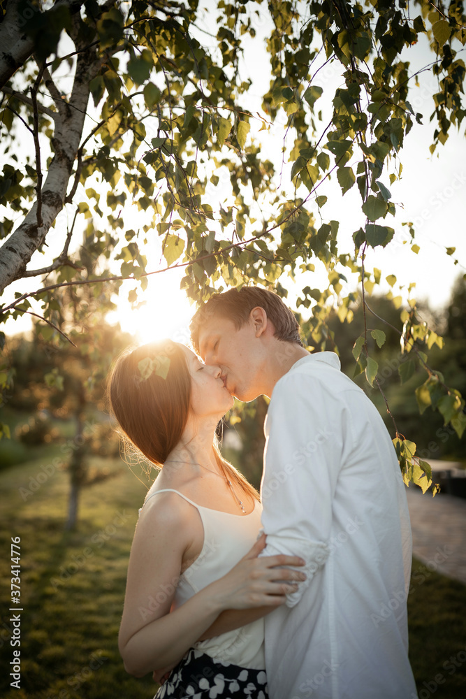 happy young couple is kissing on nature and sunset happy young couple is kissing on nature and sunset