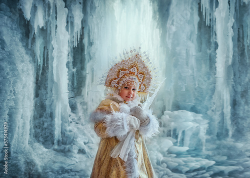 Nastya in a gold kokoshnik and fur coat with an icicle in her hands. photo
