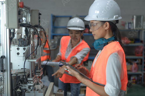 women working engineering or technical inspection the system of machinery to ensure working in order by checklist part and quality control