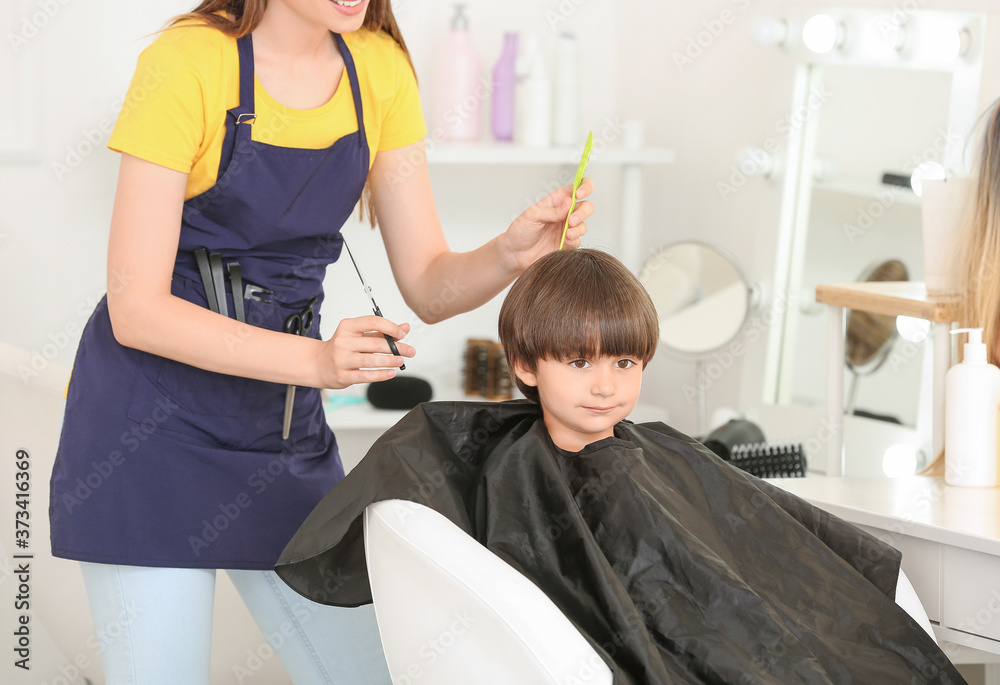 Female hairdresser working with little boy in salon Female hairdresser working with little boy in salon