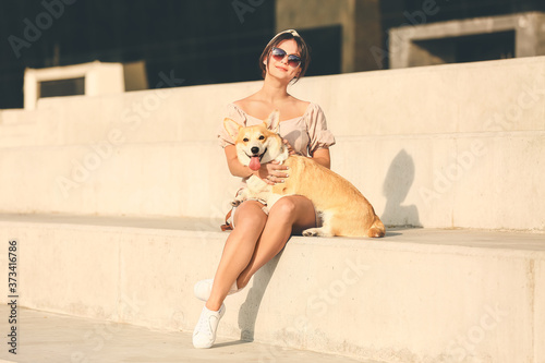 Woman with cute corgi dog w...