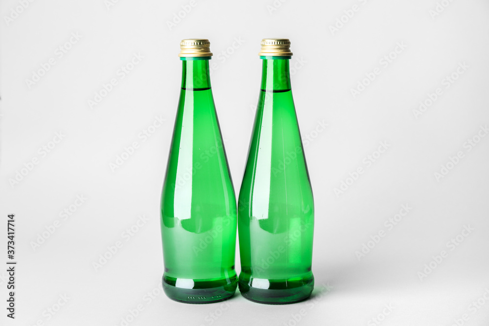 Bottles of clean water on light background