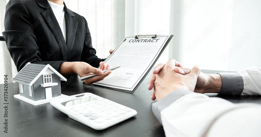 Real estate agents with house models are talking to customers about