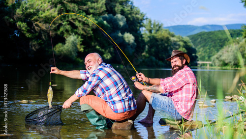 retired father and mature bearded son. big game fishing. relax on nature. fly fish hobby of men. retirement fishery. happy fishermen friendship. Two friends fishing together. Good day for fishing