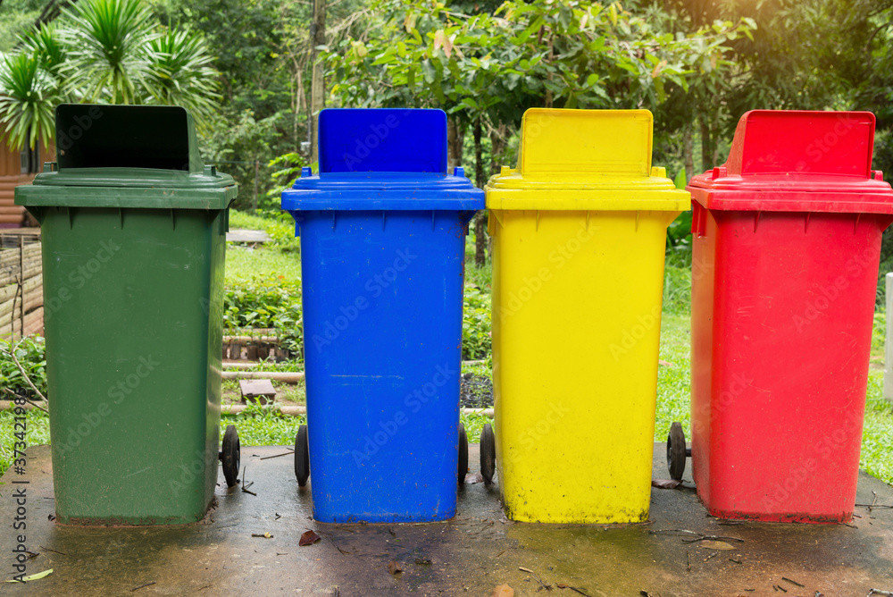 Green, blue, Yellow and red recycle bins trash can is placed on the park. Green, blue, Yellow and red recycle bins trash can is placed on the park.