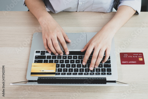 The businesswoman's hand is holding a credit card and using a laptop for online shopping and internet payment in the office © Orathai