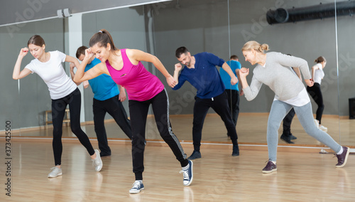 Fototapeta Naklejka Na Ścianę i Meble -  Cheerful people practicing vigorous lindy hop movements in dance class.