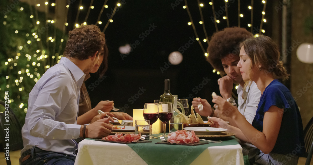 Four people, two couples happy talking and eating during a romantic gourmet dinner or lunch.Medium shot. Friends italian trip in Umbria.4k slow motion Four people, two couples happy talking and eating during a romantic gourmet dinner or lunch.Medium shot. Friends italian trip in Umbria.4k slow motion