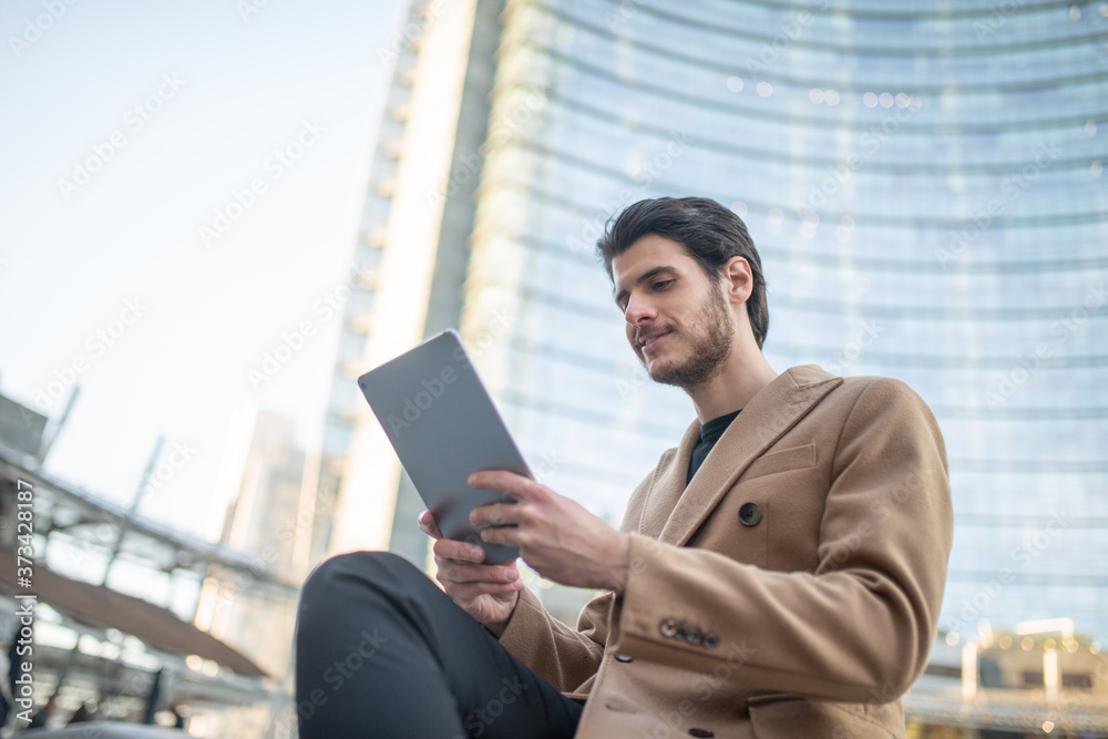 Young man using his tablet outdoor