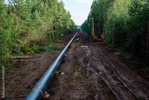 Crude oil and Natural gas pipeline construction work in forest area.  Petrochemical Pipe on top of wooden supports. Installation and Construction the Pipeline for transport gas to LNG plant