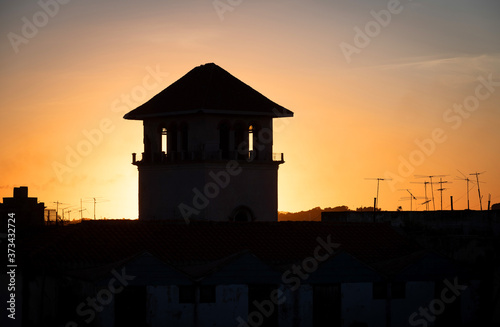 Silhouette of the upper floor of a house before sunset sky.