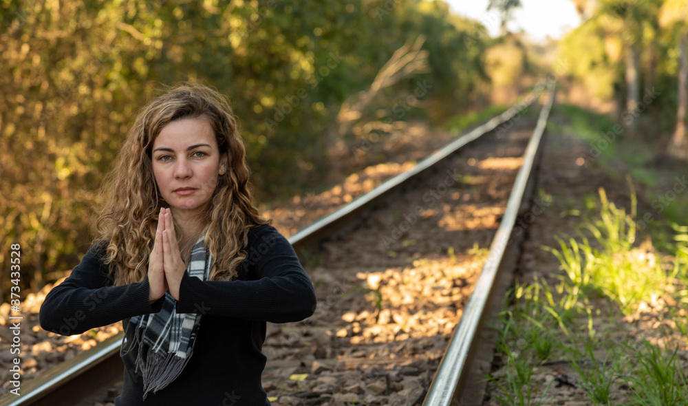 Blonde Brazilian woman meditating on the rails of a train line Blonde Brazilian woman meditating on the rails of a train line