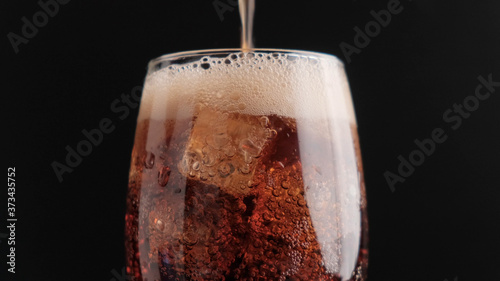 Soda with ice on a black background close-up