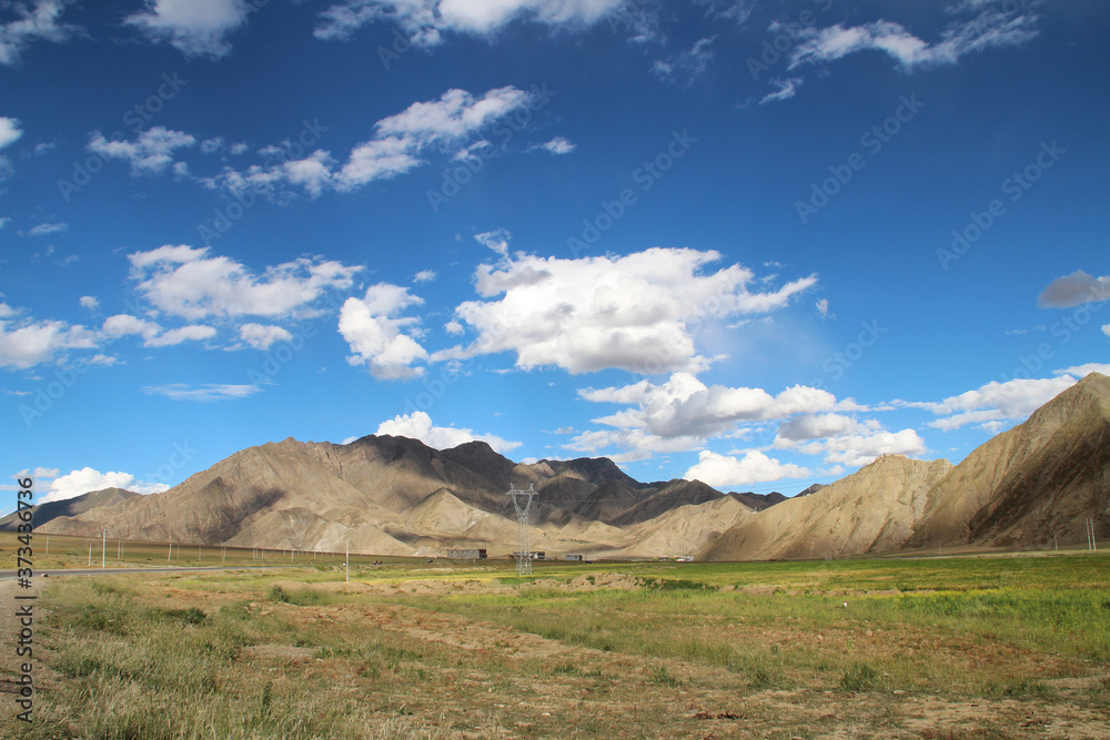 View of the mountain and Tibetan village with dramatic sky in Tibet, China 