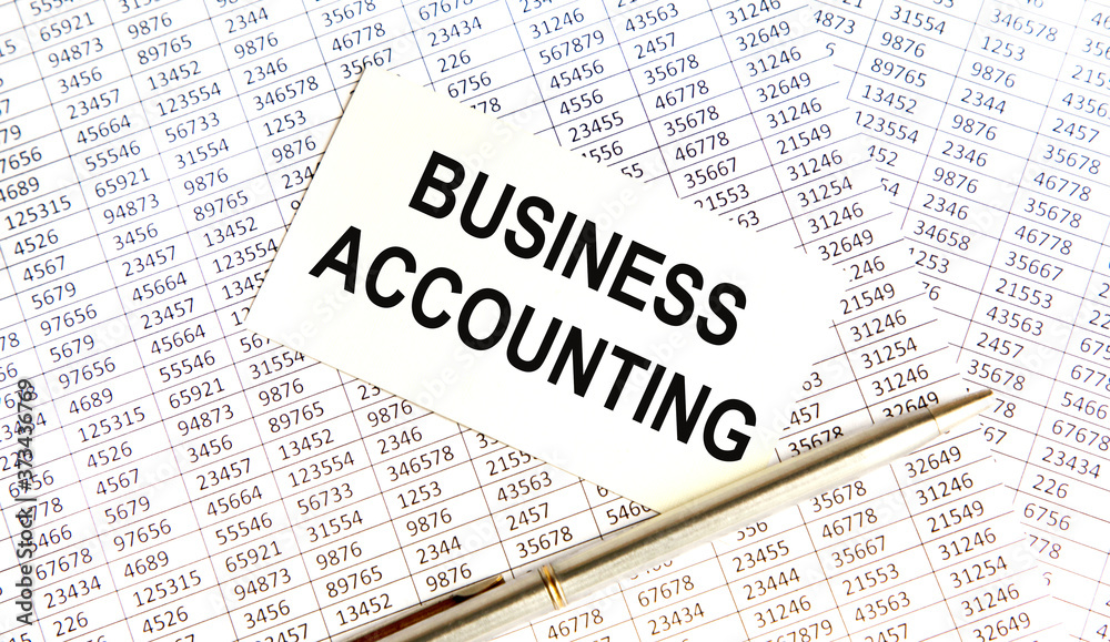 Finance and business concept. The businessman has on his desk graphs with reports, a notebook, a magnifying glass and a document with the inscription - BUSINESS ACCOUNTING Finance and business concept. The businessman has on his desk graphs with reports, a notebook, a magnifying glass and a document with the inscription - BUSINESS ACCOUNTING