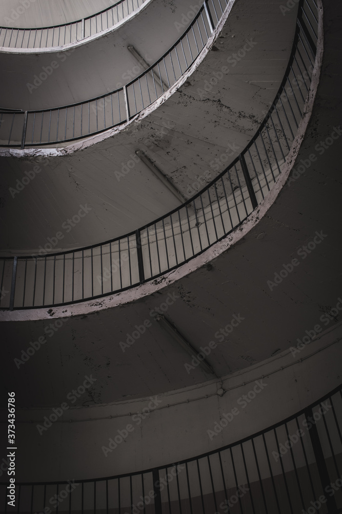 Fototapeta premium old and dirty car parking area with spiral stairs