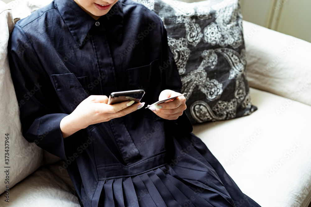 スマートフォンでオンラインショッピングをする女性 スマートフォンでオンラインショッピングをする女性