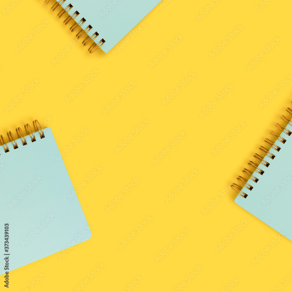 Frame made of mint spiral notepads on a yellow background. Cute school supplies. Frame made of mint spiral notepads on a yellow background. Cute school supplies.