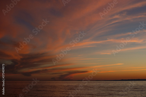 Dramatic red yellow clouds after sunset in the dusk on Lake Baikal  beautiful scenic seascape  dark moody style