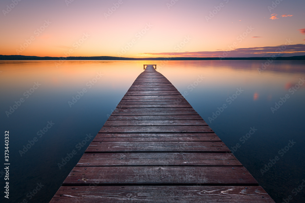 Old wooden pier at sunset. Long exposure, linear perspective