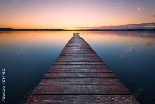 Old wooden pier at sunset. Long exposure, linear perspective