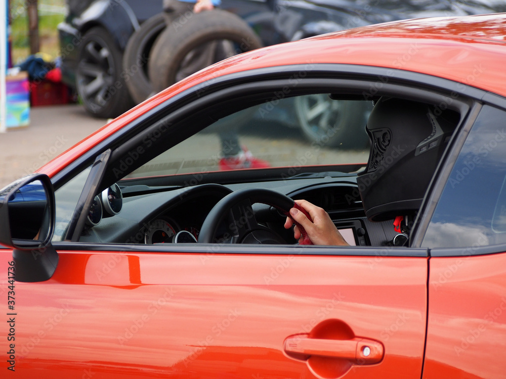 Rider in a black helmet, sitting at the wheel of a car, close-up. Active recreation, technical sports.