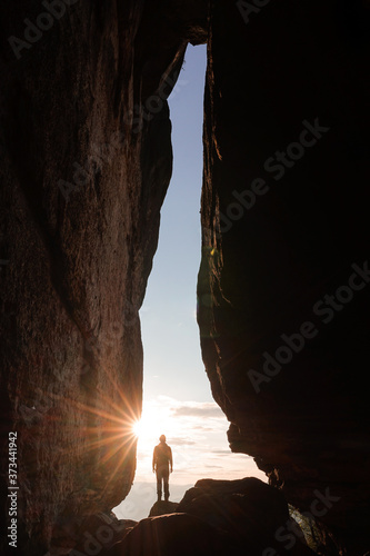 Silhouette of a person standing in a cave entrance during sunset in Saxon Switzerland, Germany