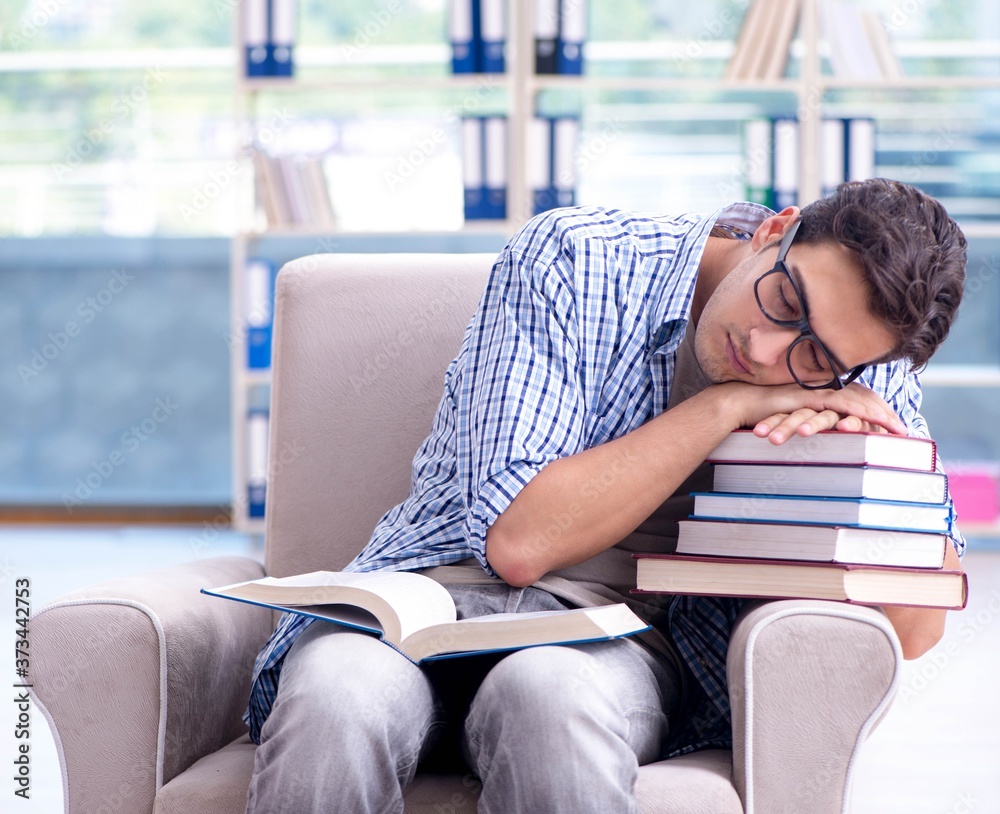 Obraz premium Student reading books and preparing for exams in library