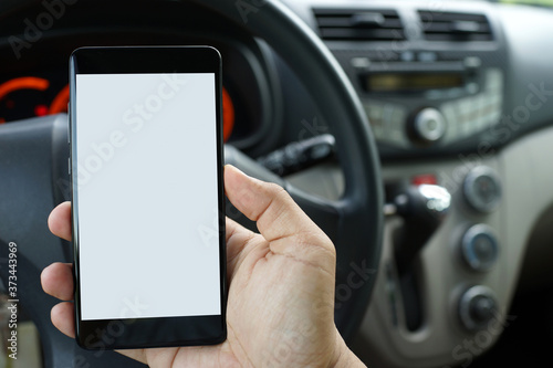 Close up adult hand holding a blank screen smartphone in car