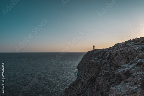 Lighthouse on a cliff on a sunset © SCTProjects