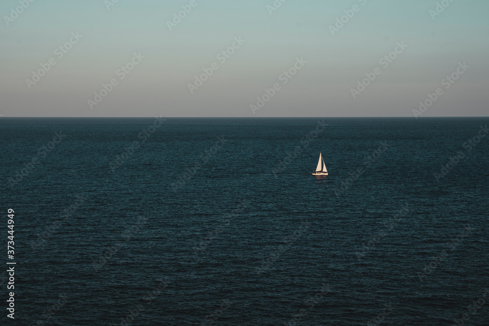 Fototapeta premium Sailboat on the ocean, blue sky, negative space