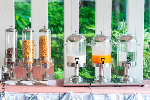 Cereal and cornflakes and milk orange juice, breakfast bar.
