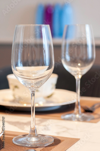 Wine glasses and tableware on dinneer table with soft light.