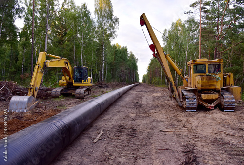 Excavator and Pipelayer with side boom o Installation of gas and crude oil pipes in ground. Construct of the gas pipes to new LNG plant
