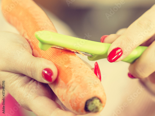 Woman peeling carrot vegetable