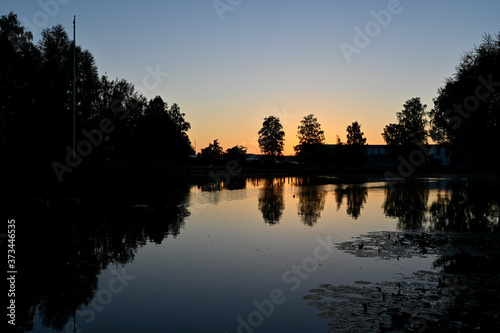 sunset over calm pond in silent park