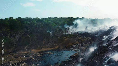 Aerial, rising, drone shot over a hill revealing dead nature, caused by the Californian wildfires, sunny day, in Los Angeles, California, USA photo