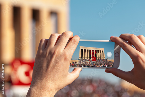 Female hand holding smartphone and taking photo of Anitkabir. Turkish people showing respect to the leader and the founder of Turkish Republic in Anitkabir mausoleum. photo