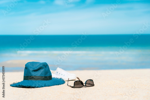 Sunglasses with hat and shoe on turquoise sea beach, Summer background